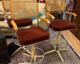 Three 70s cane backed swivel rockers 