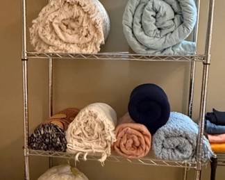 Assorted Throws and Pillows with Metal Shelving Unit