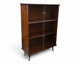 Mahogany MCM display cabinet with sliding glass doors and tapered legs with brass caps