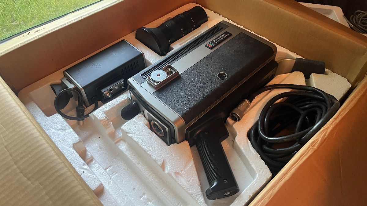 Panasonic PK-200 vintage color video camera with original packaging, including a detachable lens and viewfinder. Retro design.