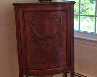 Lot 76: Antique curved-front wooden cabinet with carved panel