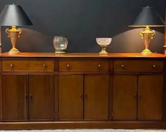 Credenza With Three Drawers And Cabinets Featuring Two Bronze Style Lamps And Ornate Decor Pieces