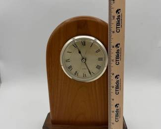 arched mantel clock features a polished light wood body