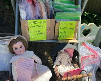 Several antique dolls and handmade vintage doll clothing and items.