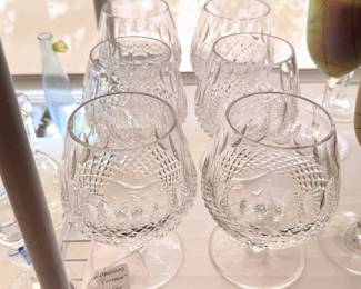 There are two table top racks of vintage Waterford crystal drinkware
