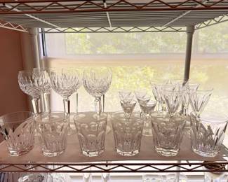 There are two table top racks of vintage Waterford crystal drinkware