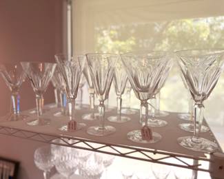 There are two table top racks of vintage Waterford crystal drinkware