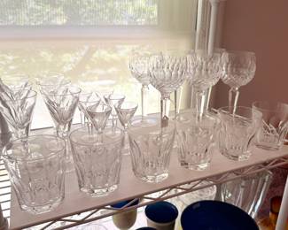 There are two table top racks of vintage Waterford crystal drinkware