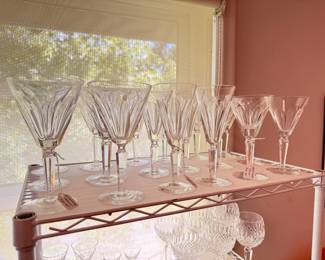 There are two table top racks of vintage Waterford crystal drinkware