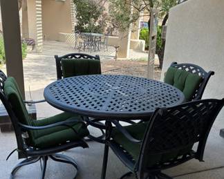 Cast aluminum dining set with swivel chairs and green cushions