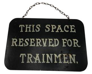 1197 - Vtg Metal Railroad Sign Reserved Trainmen (Description): Vintage metal railroad sign reading "This Space Reserved for Trainmen." The sign features white lettering on a black background with rounded corners and a chain hanger at the top. Measures 9" x 10".