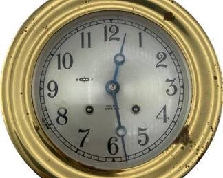 712 - Chelsea Ships Bell Brass Clock 3.75"x7.25" (Description): Chelsea Ships Bell brass clock featuring a classic nautical design. The clock has a brass case with a silvered dial and Arabic numerals. Measures 3 3/4 inches by 7.25 inches. Used as is electric/electronic/mechanical item. No guarantee all components, untested.