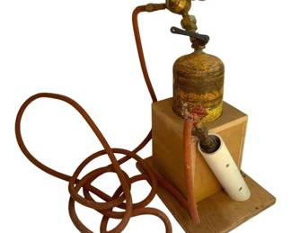 809 - Vintage Acetylene Torch Set 20" (Description): Vintage acetylene torch set featuring a tank with brass regulator and pressure gauge, attached rubber hose, and ceramic torch tip. Mounted on a wooden stand. Measures 20 inches. Used as is electric/electronic/mechanical item. No guarantee all components, untested.