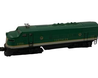 929 - Lionel Southern Locomotive 2356 3.5"x13"x3" (Description): Lionel Southern locomotive model number 2356. This O gauge diesel engine features the classic Southern Railway livery in dark green with gold and cream striping. The streamlined F3 style locomotive includes dual horn details on the roof and authentic Southern Railway markings. Measures 3.5 inches high by 13 inches long by 3 inches wide.