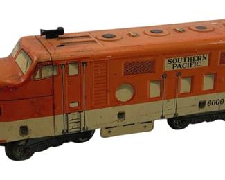 884 - Marx Tin Litho Southern Pacific Locomotive (Description): Marx tin lithograph locomotive in orange and cream Southern Pacific livery, numbered 6000. This vintage toy train features a streamlined diesel design typical of mid-century model railroads. Measures 3 inches high by 9 inches long by 2.5 inches wide.