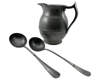123 - Vintage Pewter Pitcher & Ladles 9"x8"x5.5" (Description): Vintage pewter pitcher accompanied by two pewter ladles. The pitcher features a classic bulbous form with a graceful curved handle and flared spout. The ladles have long slender handles with rounded bowls, suitable for serving. All pieces display a characteristic aged pewter patina. Measures 9" x 8" x 5.5".