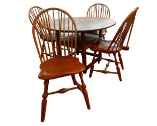 80 - Primitive Table w/ 4 Windsor Back Chairs (Description): Primitive wooden table accompanied by four Windsor back chairs. The set features warm honey-toned wood with traditional spindle back construction on the chairs. The table measures 35.5" x 15" x 20" and the chairs measure 27" x 42". Classic Americountry style with turned legs on both the table and chairs.
