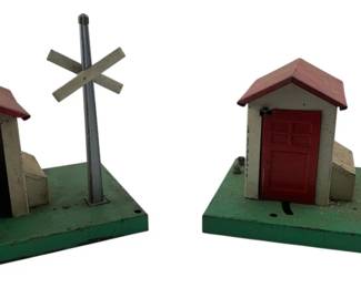 230 - 2 Lionel Post War Automatic Gateman Accessories (Description): These classic train layout pieces features a small building with a railroad crossing sign, designed to add realistic action to model railroad displays.