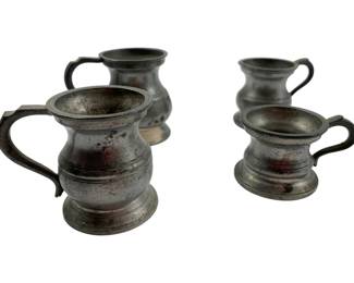 135 - Group of 4 Antique Mini Pewter Tankards 2" (Description): Group of four antique miniature pewter tankards. These small vessels feature traditional baluster-shaped bodies with scrolled handles and footed bases. The pewter displays a beautiful aged patina consistent with their antique age. Each tankard measures 2 inches in height.