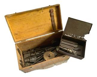821 - Lot Antique Tools w/ Wood Boxes 9"x16"x8" (Description): A lot of antique tools housed in two wooden boxes. The collection includes various metal tools such as wrenches, drill bits, and other machinist or mechanical implements. One box features a hinged lid with a leather strap closure, while the other appears to be a metal tool tray with compartments. The tools show age-appropriate patina consistent with their antique nature. Measures 9" x 16" x 8".