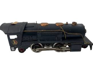 323 - Vtg Lionel Black Steam Locomotive 3"x3"x10" (Description): Vintage Lionel steam locomotive in black painted metal finish. This classic O-gauge train engine features copper-colored dome caps, brass handrails, and the iconic Lionel 'L' logo on the cab. The locomotive has detailed drive wheels with connecting rods and shows authentic age-related wear consistent with mid-century Lionel production. Measures 3"x3"x10".