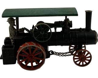 1123 - Antique Cast Iron Case Tractor Toy (Description): Antique Case tractor toy crafted in cast iron. This charming piece features a seated driver figure, green canopy roof, black boiler with "CASE" embossed on the side, red spoked wheels, and a decorative chain. The toy displays characteristic early 2th century design with nicely detailed mechanical elements. Measures 5" x 8" x 5.5" x 4.5" x 4.5".