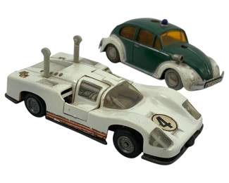 735 - Schuco Group of 2 Wind Up Cars 4"x2" (Description): Schuco group of two wind up cars. The lot includes a white racing car and a two-tone Volkswagen Beetle. Measures 4 inches by 2 inches.