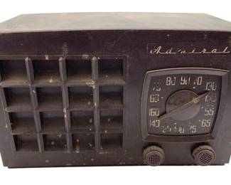 787 - Admiral Radio 6.5"x10.5"x5.5" (Description): Admiral radio measuring 6 1/2" x 10 1/2" x 5.5". This vintage tabletop radio features the classic Admiral script logo on the front panel, a grid-style speaker grille, and a round dial tuner with two control knobs. Used as is electric/electronic/mechanical item. No guarantee all components, untested.