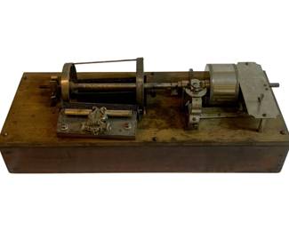 1048 - Antique Music Box (Description): Antique music box featuring exposed mechanical components mounted on a wooden base. The mechanism includes the characteristic cylinder and comb assembly typical of traditional music boxes. Used as is electric/electronic/mechanical item. No guarantee all components, untested.