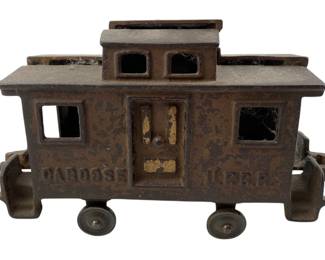 183 - Vtg Cast Iron Toy Train Caboose P.R.R. (Description): Vintage cast iron toy train caboose marked "CABOOSE" and "P.R.R." on the sides. This sturdy toy features a raised cupola with window cutouts, platform railings on both ends, and four wheels. The caboose displays a weathered brown patina with trace of original gold paint visible on the door. Measures 4 1/2" x 8" x 2.5".