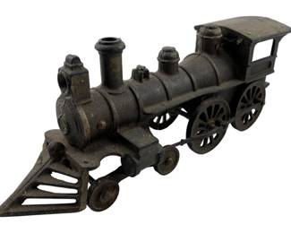177 - Vintage Cast Iron Toy Train 3.5"x10"x2.5" (Description): Vintage cast iron toy train locomotive featuring a classic steam engine design with cow catcher, smoke stack, boiler, cab, and spoke wheels. The piece displays an aged dark patina consistent with its vintage character. Measures 3 1/2" x 10" x 2.5"