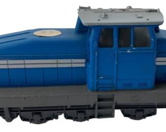 290 - Marklin Blue Diesel Locomotive Train Engine (Description): Marklin locomotive featuring a blue body with silver striping accents and a gray chassis. This diesel-style engine has a detailed cab section with windows and rooftop ventilation. The locomotive rides on a six-wheel truck configuration with metal handrails at each end. Measures 2"x2"x5".