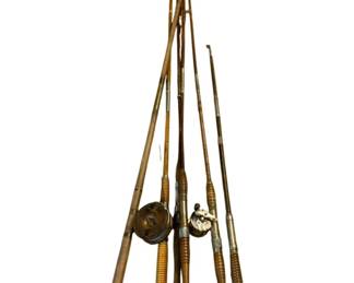 1140 - Lot Antique Fishing Rods 84" (Description): A lot of antique fishing rods measuring 84 inches in length. The collection features multiple bamboo and wood fishing rods with turned wooden handles and cork grips. Two rods are fitted with vintage fly reels, including one brass reel and one nickel-plated reel. The rods display the characteristic multi-piece construction and wrapped guides typical of early 20th century fishing equipment.