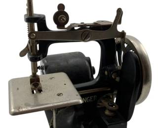24 - Singer Model 20 Mini Sewing Machine 7"x7"x7" (Description): Singer Model 20 mini sewing machine in black finish with chrome and nickel-plated accents. This vintage toy or child's sewing machine features a hand crank mechanism, metal construction, and the classic Singer branding. The machine retains its original components including the needle bar, thread tension mechanism, and sewing plate. Measures 7" x 7" x 7". Used as is electric/electronic/mechanical