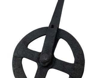 178 - Ant. Cast Iron Wheelwrights Traveler (Description): Antique cast iron wheelwrights traveler, a traditional tool used by wheelwrights to measure wheel circumference. Features a four-spoke wheel design with a long tapered handle and center pivot bolt, finished in a dark blackened patina. Measures 14" x7".
