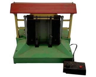 942 - Lionel #164 Lumber Shed 9"x11"x11" (Description): Lionel #164 Lumber Shed with remote control unit. This vintage toy train accessory features a covered shed structure with spring-loaded mechanisms. Measures 9 inches by 11 inches by 11 inches.