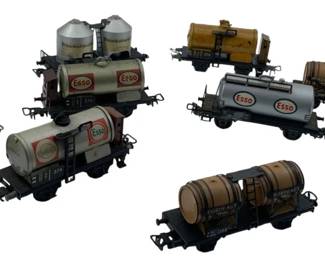 278 - Group Lot 10 Gasoline/Water Carriers 2"x1"x4" (Description): A group lot of ten model gasoline and water carrier train cars. The collection includes various tanker and barrel cars featuring Esso branding and other markings. Each car measures approximately 2 inches high by 1 inch wide by 4 inches long.