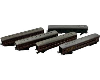 1194 - 5pc. O Scale Model Train Passenger Cars (Description): Collection of five O scale model train passenger cars. The set includes four matching maroon and silver-roofed coaches marked "MITROPA" with detailed windows and ventilation details, plus one dark green passenger car. All cars feature period-appropriate styling with brown/maroon body panels and silver rooftops. Measures 2" x 9" x 4.5".