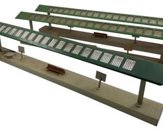 241 - Vintage Kirby Train Terminals 5"x19"x7" (Description): Vintage Kirby train terminals featuring painted metal construction with distinctive windowed canopy roofs. The set includes multiple platform pieces with attached miniature benches and signage details. Measurements: 5" x 19" x 7".