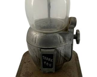978 - Vintage 5cent Candy Gumball Machine 11"x10"x8" (Description): Vintage 5¢ candy gumball machine featuring a glass globe top, metal body with Art Deco-style ribbed detailing, and a "Thank You" dispensing plate on the front. The machine has a turn knob mechanism on the side and sits on a square metal tray base.measures 11 inches by 10 inches by 8 inches. Used as is electric/electronic/mechanical item. No guarantee all components, untested.