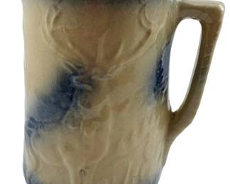 88 - Robinson Ransbottom Stoneware Pitcher (Description): Robinson Ransbottom stoneware pitcher featuring a molded elk or stag design in relief. The pitcher displays the characteristic blue and tan salt-glazed finish typical of this pottery. Measures 8.25" x 8" x 5".