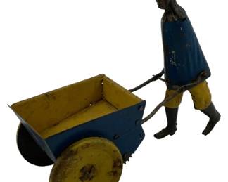 1189 - Vtg Tin Litho Wind-up Man w/ Cart Toy (Description): Vintage tin lithograph wind-up toy featuring a figure of a man pushing a two-wheeled cart. The toy is painted in blue and yellow tones, with the figure wearing a blue tunic and yellow pants. The cart features yellow wheels and interior with blue exterior panels. Shows age-appropriate wear to the painted surfaces. Measures 6" x 3" x 4".