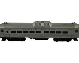 932 - Lionel #400 Baltimore and Ohio Passenger Car (Description): Lionel #400 Passenger Car in silver with Baltimore and Ohio railroad livery. This O-gauge model features blue lettering and numbering, multiple passenger windows along the sides, and a rooftop ventilation unit. The car rides on black trucks and is marked with the number 400 on both ends. Measures 4 inches high by 15 inches long by 3 inches wide.