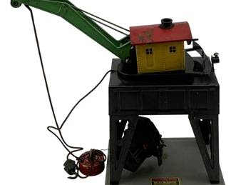 1012 - American Flyer Metal Crane 10" (Description): American Flyer metal crane toy accessory. This vintage train accessory features a rotating crane mechanism with a green boom arm and yellow cab house with red roof, mounted on a black metal tower base. Measures 10 inches.