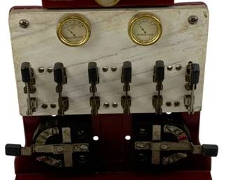 956 - Lionel No. 439 Panel Board 8"x7"x3.25" (Description): Lionel No. 439 Panel Board. This vintage train accessory features a maroon painted metal frame with a white marble-effect panel displaying a volt meter and ammeter with brass bezels, multiple knife switches, and two large controllers at the base. The unit includes brass nameplates with the Lionel branding. Measures 8" x 7" x 3.25". Used as is electric/electronic/mechanical item. No guarantee all components, untested.