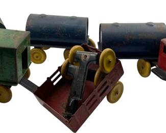 289 - Vtg Metal Truck w/ 5 Pull Behind Trailers (Description): Vintage metal truck with five pull behind trailers featuring water containers. The set includes a red cab truck and various colored trailers with yellow wheels. Measures 4 x 4 x 7 inches and 5 x 4 x 6 inches.