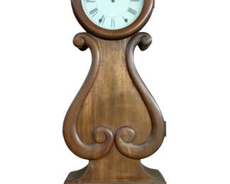799 - Antique Wood Wall Clock Case 36"x13"x4.5" (Description): Antique wood wall clock featuring a lyre-shaped case with decorative scrollwork details. The clock has a round face with Roman numerals. Measures 36 inches tall by 13 inches wide by 4.5 inches deep. Used as is electric/electronic/mechanical item. No guarantee all components, untested.