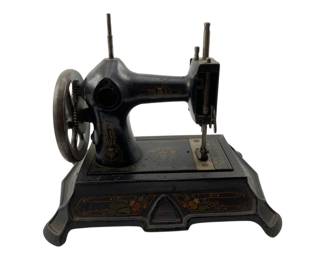 13 - Vtg Miniature Sewing Machine Germany (Description): Vintage miniature sewing machine made in Germany. This charming piece features a black painted cast iron body with decorative hand-painted floral and scroll motifs in red, green, and gold. The base displays a folk art style with tulip designs. Complete with hand wheel, spool pins, and needle mechanism. Measures 8" x 9.5" x 6.5". Used as is electric/electronic/mechanical item. No guarantee all components, untested.