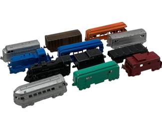 1130 - Tootsie Toy Metal Trains Lot (Description): Collection of Tootsie Toy metal trains featuring various locomotives, passenger cars, freight cars, and a caboose. The lot includes pieces in blue, silver, black, green, orange, brown, and red finishes. These vintage die-cast trains showcase classic mid-century styling. Measurements approximately 1.25" x 4" x 1".