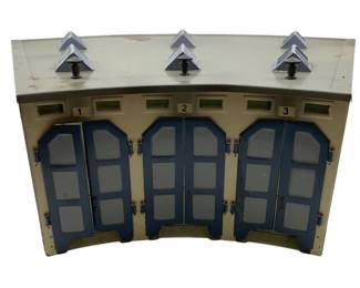 356 - Marklin Germany Metal 3 Stall Roundhouse (Description): Marklin Germany metal 3 stall locomotive roundhouse. This model train accessory features three numbered bays with hinged double doors and decorative roof vents. Measures 5 inches by 18 inches by 14 inches.